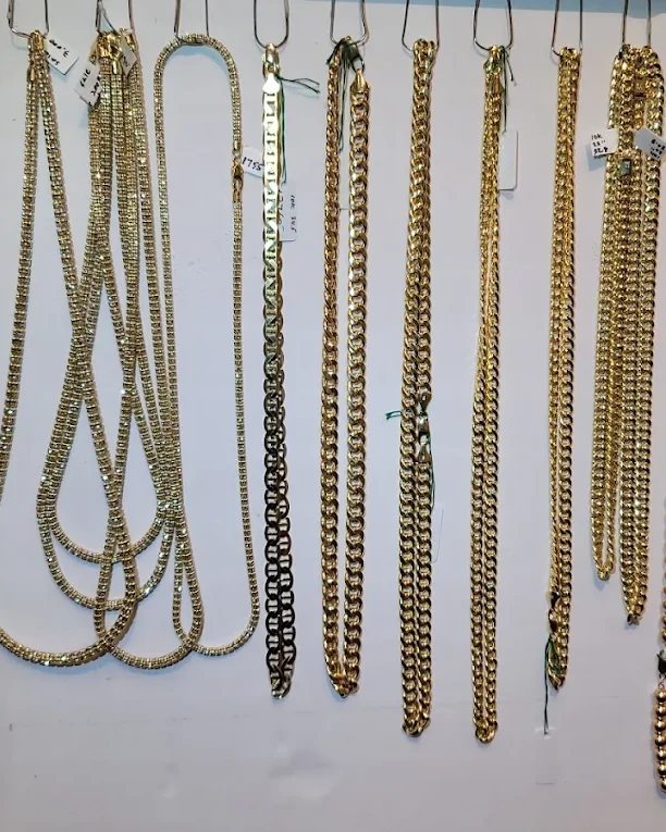 Gold Cuban, tennis and bead chains hanging on a jewelry store display wall