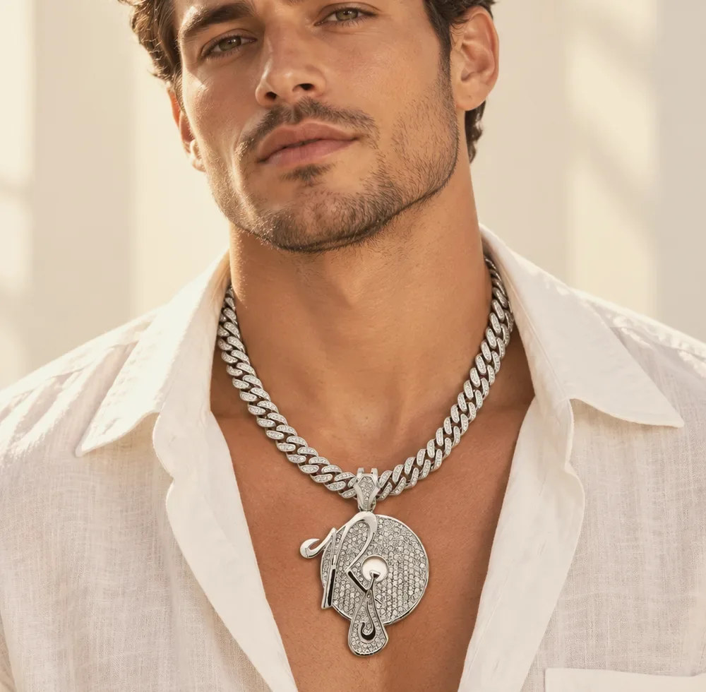 Man in an open white linen shirt wearing an iced Cuban chain with a custom pendant