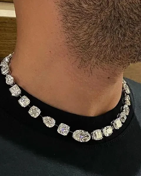 Man in a black tee wearing a heavy iced-out tennis choker with large clear stones