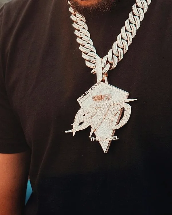 Large iced pendant on an iced Cuban chain over a black tee