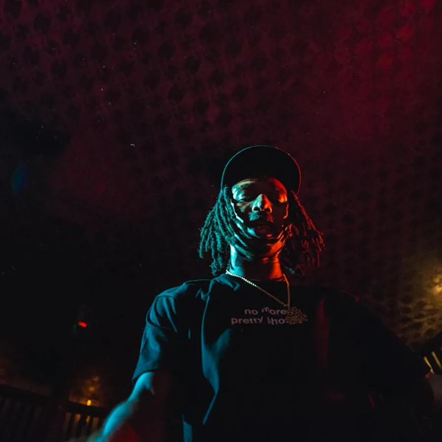 Man in sunglasses under red studio lights