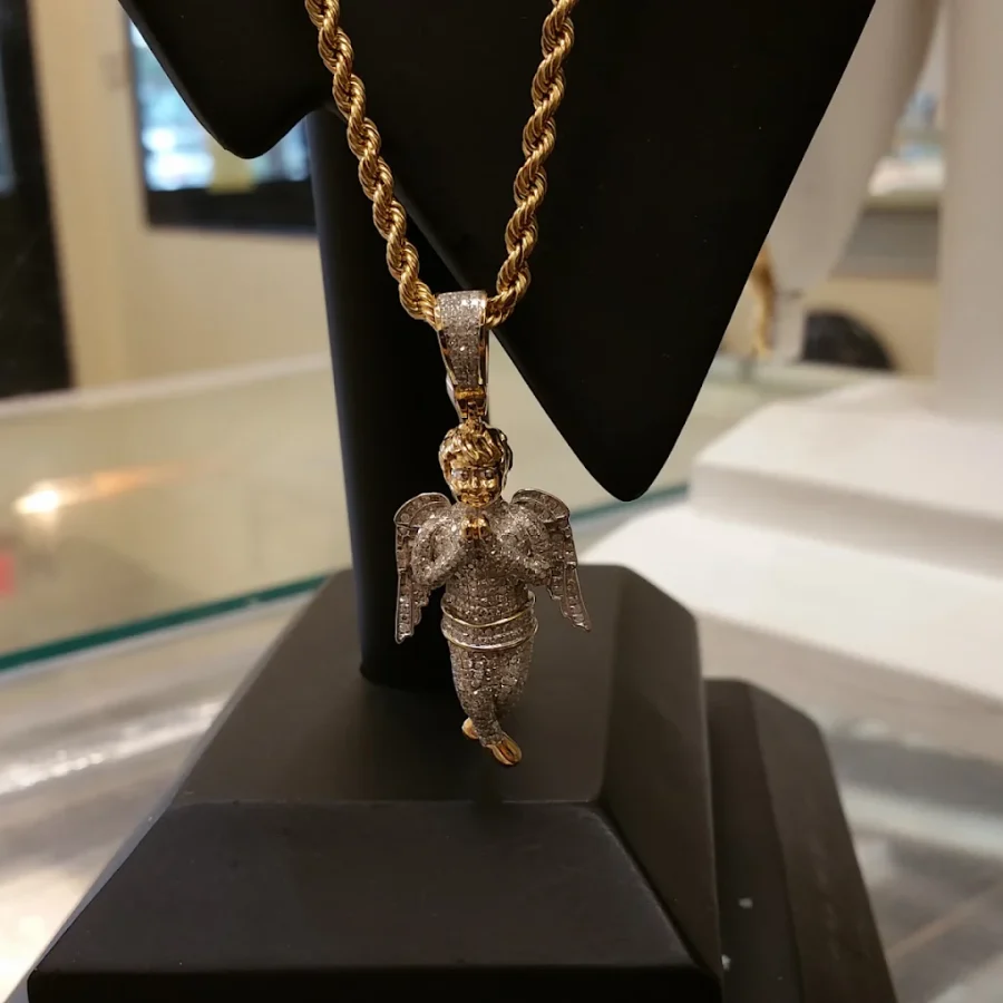 Iced praying angel pendant on a gold rope chain on a display stand