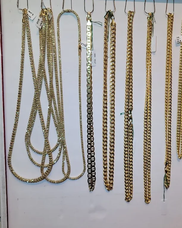 Gold Cuban, tennis and Mariner chains on the chain wall inside the store